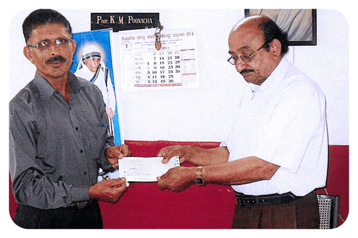 Marchanda Ganesh Ponnappa, Trustee, presenting a cheque to Sri Rama Trust School, Napoklu.