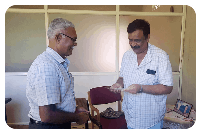 Shri Mandapanda Sada Chengappa, President KESST, handing over cheque to Sai Shankar School Ponnnampet (to Shri Kolera Zaroo Ganapathy) for financial assistance for education of flood affected children.